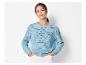 Femme en pull en maille bleu clair et pantalon blanc