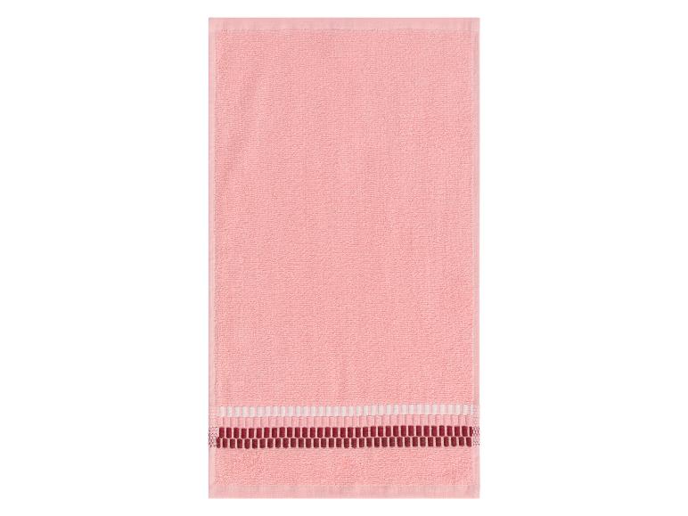 Een roze handdoek met een decoratieve rand.