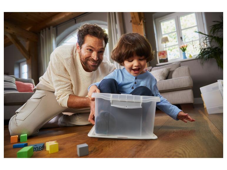 Un père et son fils jouent avec des blocs et une boîte de rangement.