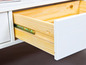 Een open witte lade met houten binnenkant.