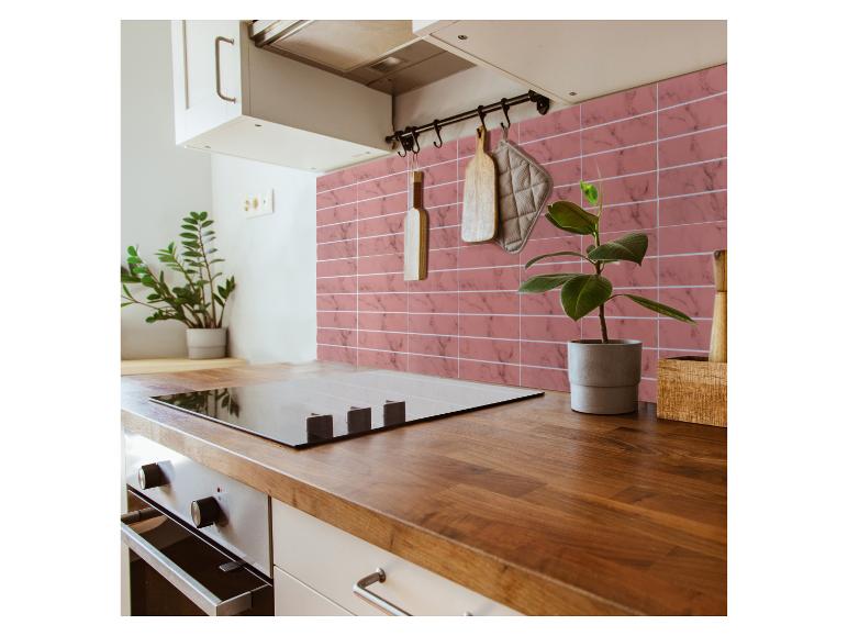 Moderne keuken met houten aanrechtblad, zwarte kookplaat en roze marmerlook tegels.