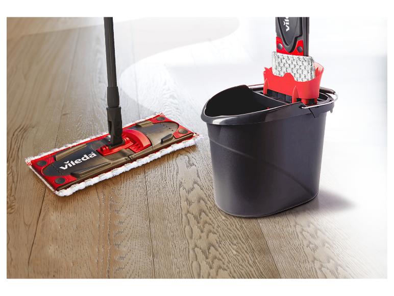 Serpillière et seau Vileda sur un sol en bois.
