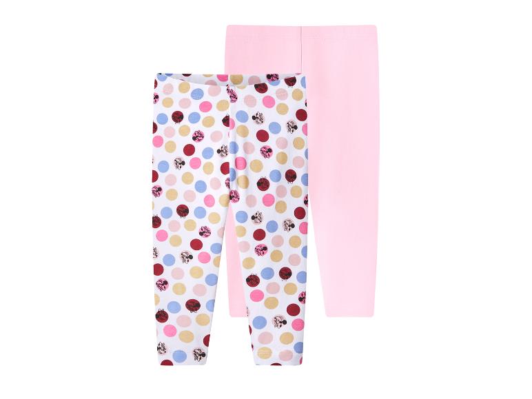 Twee meisjesleggings, één met kleurrijke stippen en de andere effen roze.