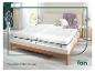 Twee 'fan' matrassen op een houten bedframe.