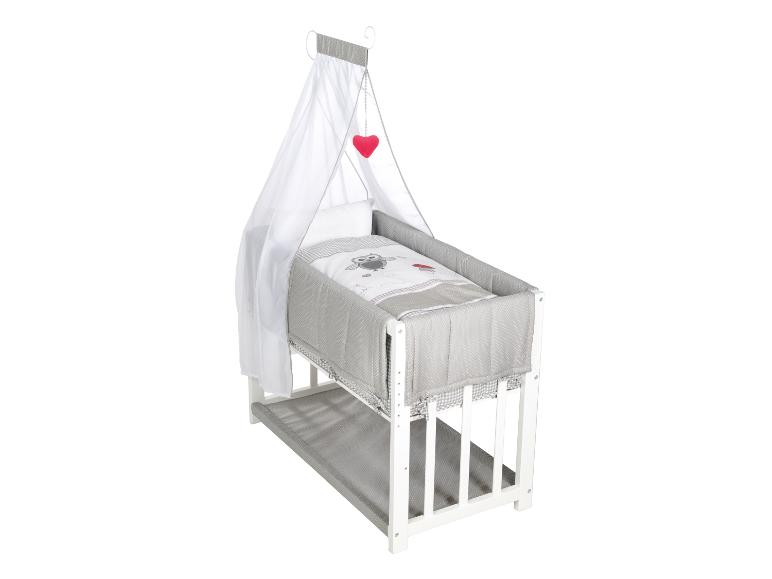 Wit houten babybedje met hemel, grijs beddengoed met uil en rood hart.