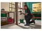 Homme utilisant une perceuse-visseuse pour fixer une planche en bois dans un atelier.