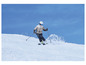 Een skiër daalt een besneeuwde helling af.