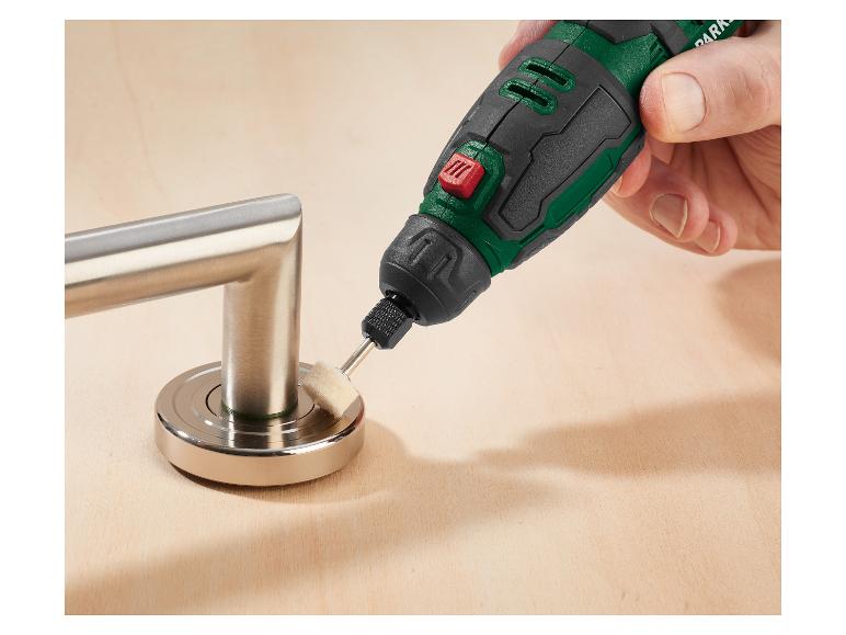 Roterend gereedschap polijst een metalen deurklink op een houten oppervlak.