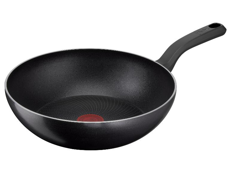 Zwarte wokpan met handvat en rode temperatuurindicator op de bodem.