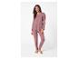 Femme souriante dans un ensemble de pyjama mauve à manches longues et pantalon.