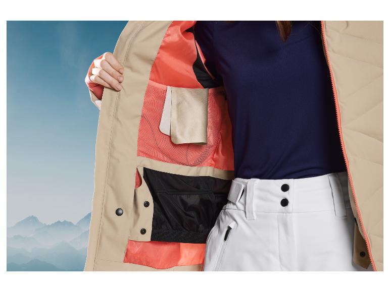 Beige skijak met roze voering en witte broek.