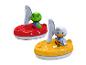 Deux bateaux jouets avec figurines, un rouge avec une grenouille verte et un jaune avec un canard blanc.