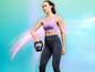Een vrouw in sportkleding houdt een kettlebell vast.