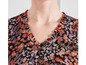 Een zwarte blouse met een V-hals en een bloemenprint.