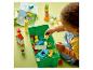 Un enfant joue avec des briques et des figurines LEGO DUPLO, avec une boîte de rangement.