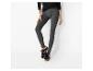 Vrouw in grijze legging en zwarte sneakers met bruine zool.