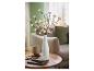 LED-lichtgevende takken met witte bloemen in een vaas, op een houten tafel met notitieboekje en bril.
