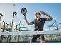 Man speelt padel, houdt een padelracket vast, met een tennisbal in de lucht.