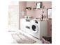 Moderne wasruimte met wasmachine, witte kasten, houten aanrechtblad en minimalistische decoratie.