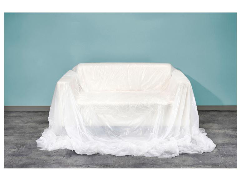 Bank bedekt met wit plastic folie voor een lichtblauwe muur