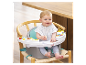 Baby in een Infantino kinderstoel met speelblad.