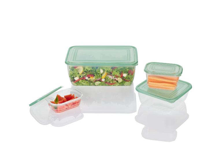 Transparante bewaardozen met salade, wortels en watermeloen.
