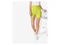 Limoenkleurige shorts en witte sneakers.