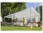 Familie onder een witte partytent in de tuin, klaar om aan tafel te eten.