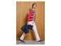 Vrouw in rood-wit gestreepte top, witte broek en donkerblauwe sneakers, met een donkerblauwe jas.
