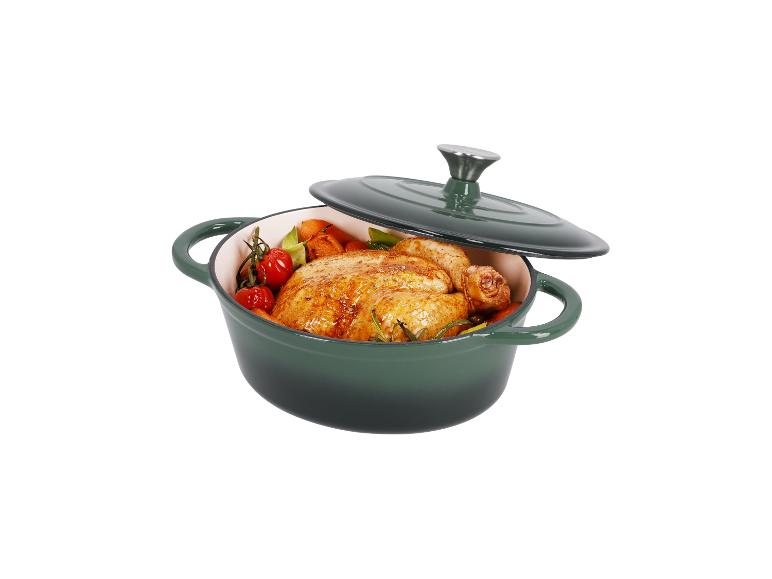 Un poulet rôti avec des légumes dans une cocotte en fonte verte.