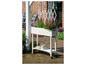 Een witte plantenstandaard met bloeiende heide en andere planten.