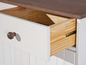 Een witte lade met houten handvat, opengetrokken om de houten binnenkant te laten zien.