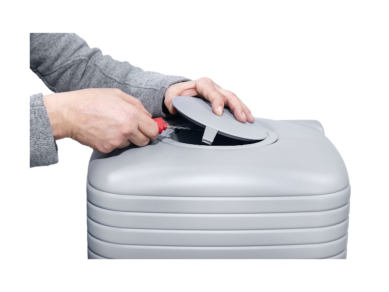 Une personne ouvre le couvercle d'une citerne d'eau grise.