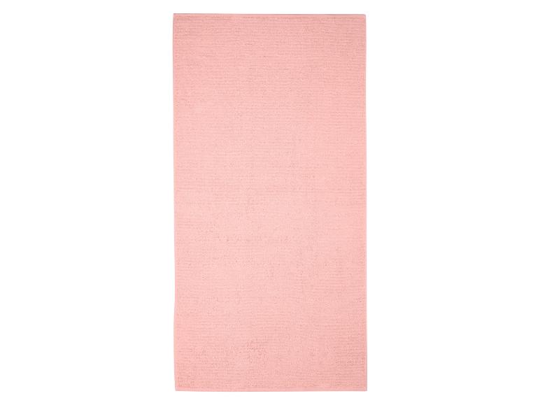 Roze geribbelde badhanddoek op een witte achtergrond