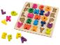Puzzle en bois avec des lettres de l'alphabet colorées, certaines hors du plateau.