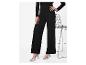 Pantalon noir pailleté et escarpins argentés, à côté d'une chaise en métal.