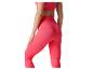 Femme en brassière de sport côtelée rose et leggings assortis.