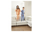 Twee kinderen in pyjama's springen op een witte bank.