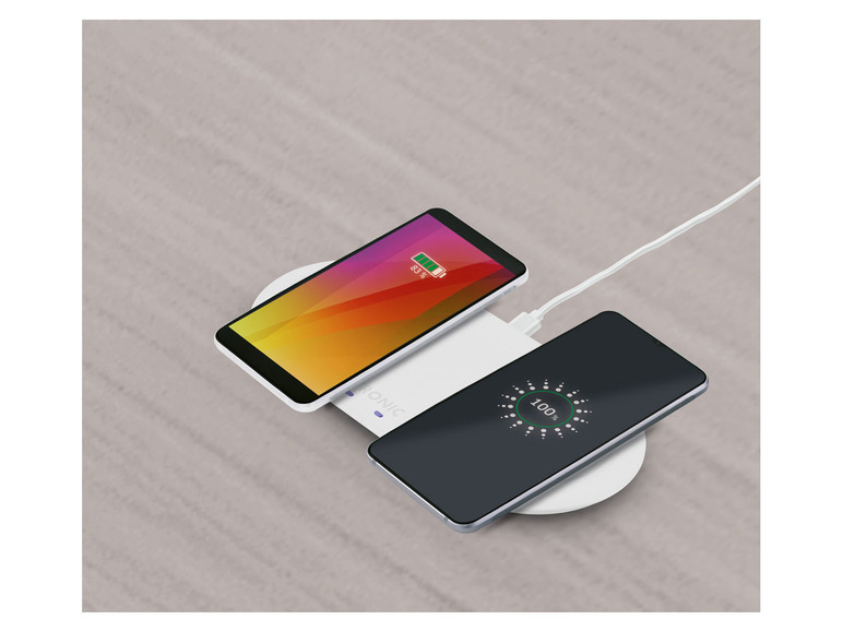 Twee smartphones worden opgeladen met een draadloze oplader.