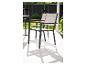 Tuinstoelen met houten armleuningen op een wit terras.