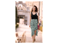 Robe noire, jupe midi à pois, et chaussures plates : une femme se promène avec son chien.