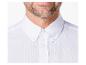 Homme en chemise blanche à col boutonné et barbe.