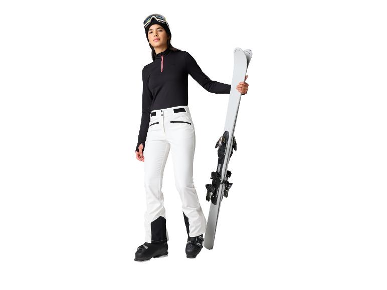 Vrouw in zwart-witte ski-uitrusting, met ski's.