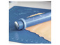 Een blauwe deegroller van Cook op een blauwe bakmat met deeg.