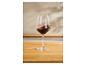 Verre de vin rouge sur un comptoir en bois.
