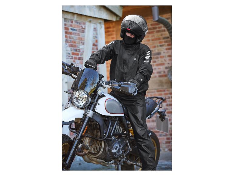 Een motorrijder op een witte Ducati Scrambler met zwarte kleding en een helm.