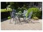Ensemble de mobilier de jardin en métal gris avec table et quatre chaises sur une terrasse en briques.