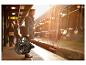 Homme en manteau tenant un vélo pliant sur un quai à côté d'un train.
