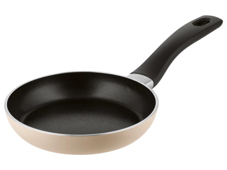 Poêle à frire beige avec revêtement antiadhésif noir et manche noir.