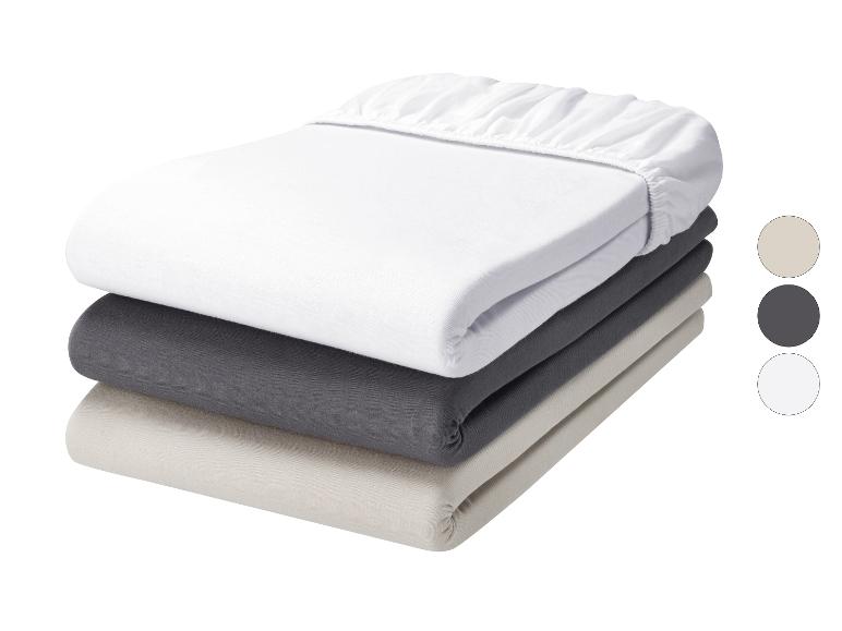 Lot de 3 draps-housses en blanc, gris foncé et beige.
